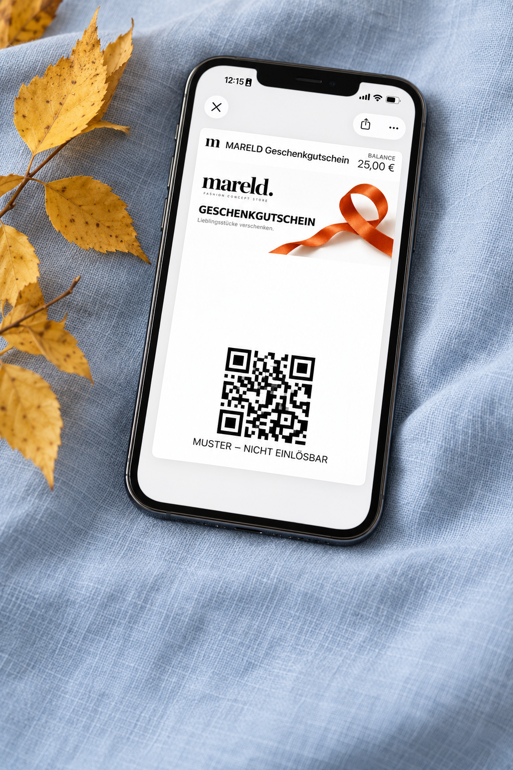 MARELD-Gutschein in der Wallet auf hellblauem Leinen mit Herbstlaub